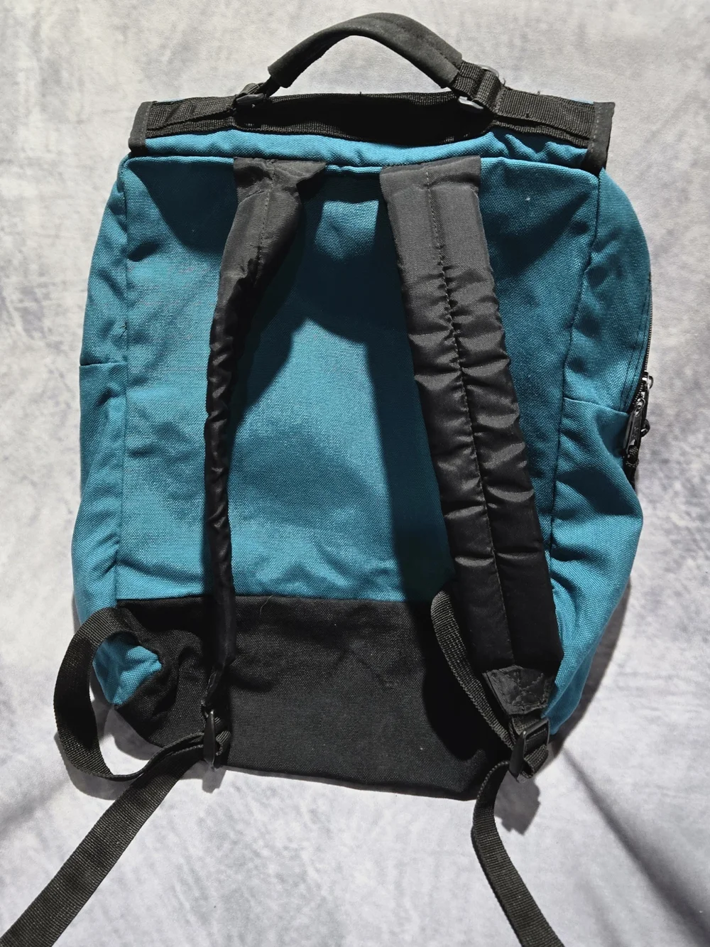 vintage 1990s turquoise and black JanSport canvas backpack featuring a top flap